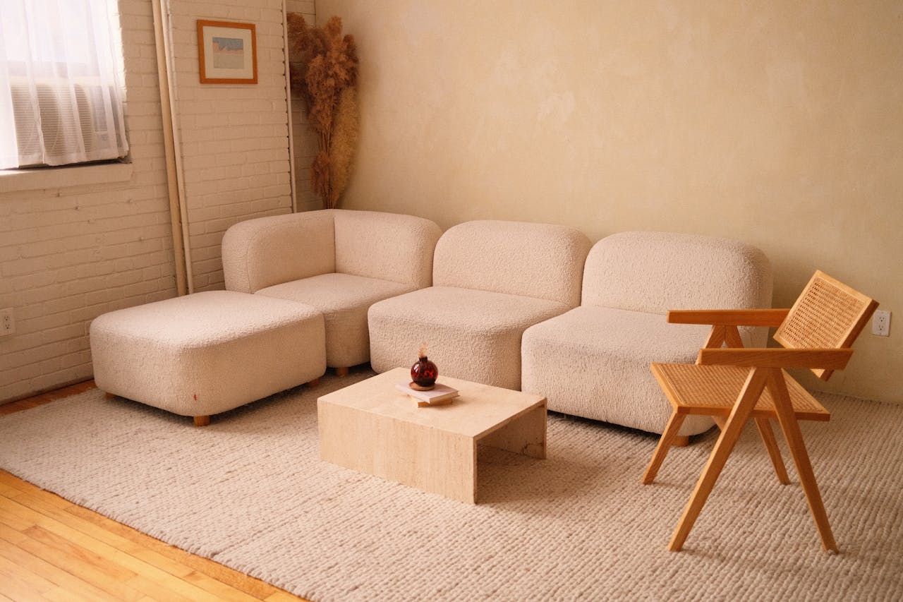 why-choose-us A cozy minimalist living room featuring a plush sofa and contemporary wooden chair.